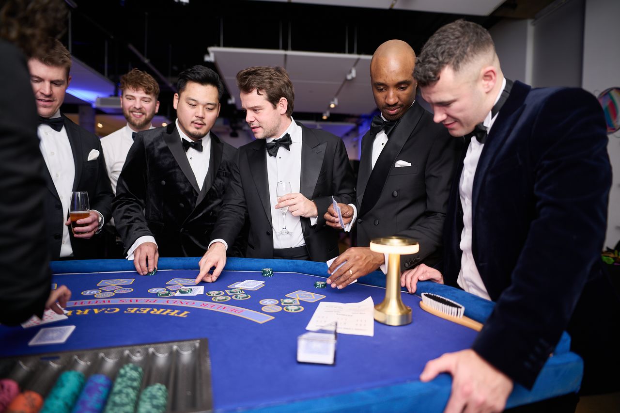 Black-tie guests around the casino tables at an evening event