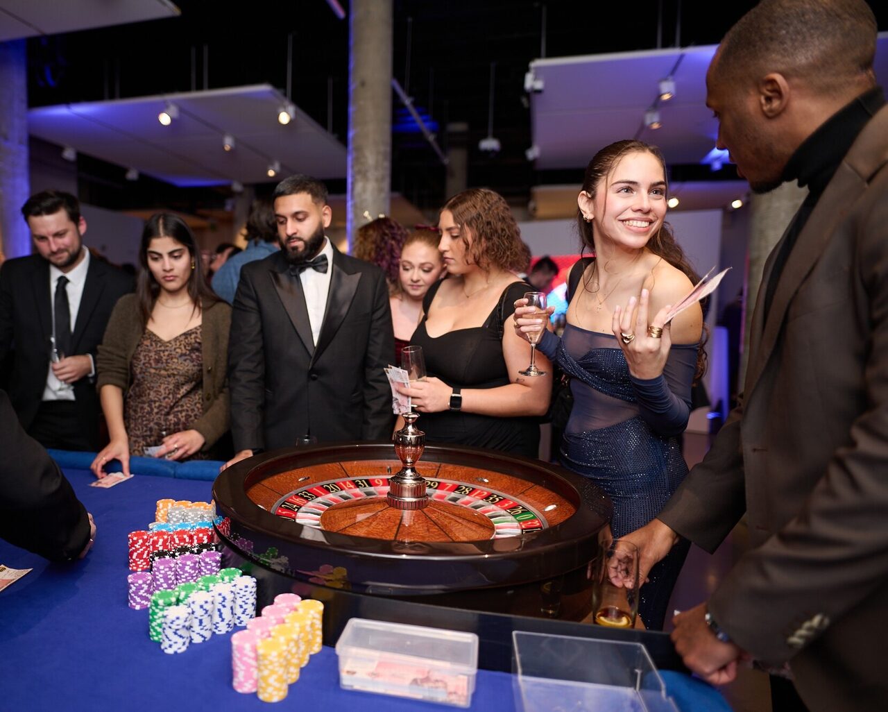 Smartly dressed guests gathered around a roulette wheel at a London casino night