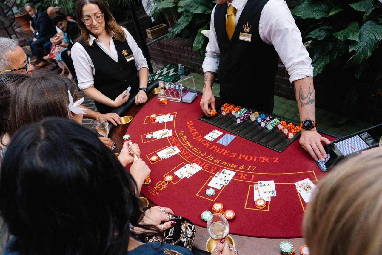Two Royale croupiers hosting a blackjack table for wedding guests at the Barbican Conservatory