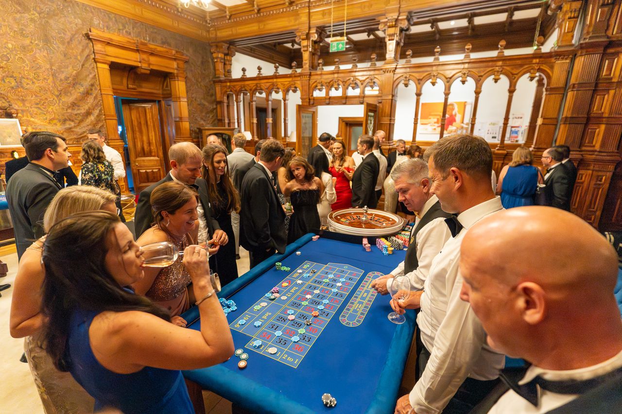 Guests gathered around the tables at a large casino event