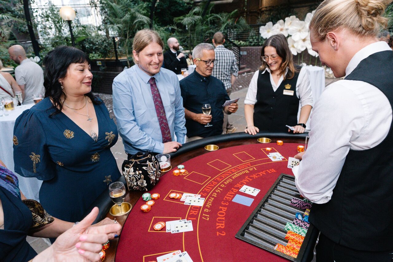 Three generations of wedding guests playing blackjack together with two Royale croupiers