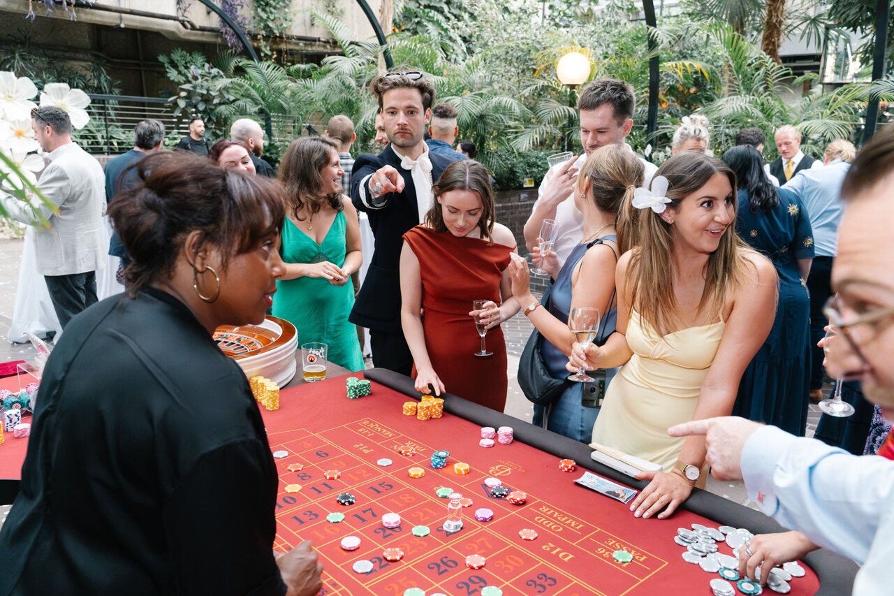 Wedding guests crowded around a Royale roulette table at the Barbican Conservatory