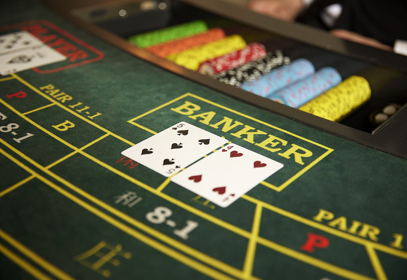 A Royale baccarat table mid-hand, with the Banker box dealt