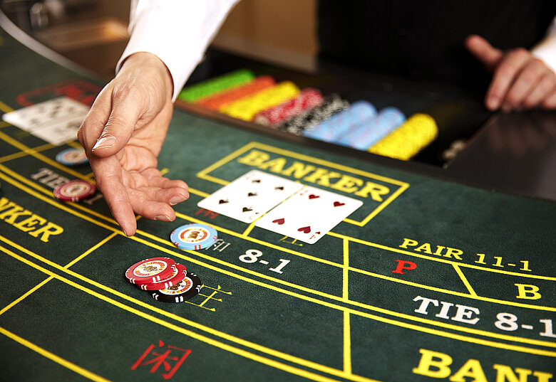 A croupier settling chips at a Royale baccarat table