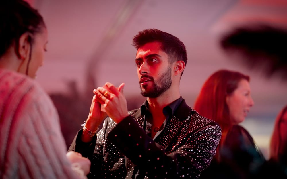 Magician Akshay Badiani of AK Magic performing close-up sleight of hand for a guest at an event